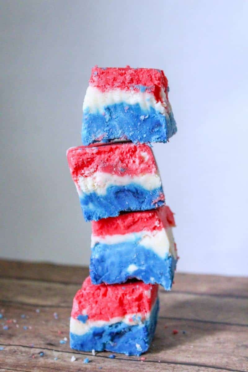 A red, white, and blue marshmallow creme fudge recipe made with marshmallow creme, evaporated milk, white chocolate chips, sugar, butter, and food coloring.