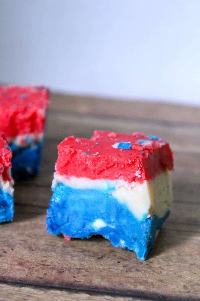 A red, white, and blue marshmallow creme fudge recipe made with marshmallow creme, evaporated milk, white chocolate chips, sugar, butter, and food coloring.