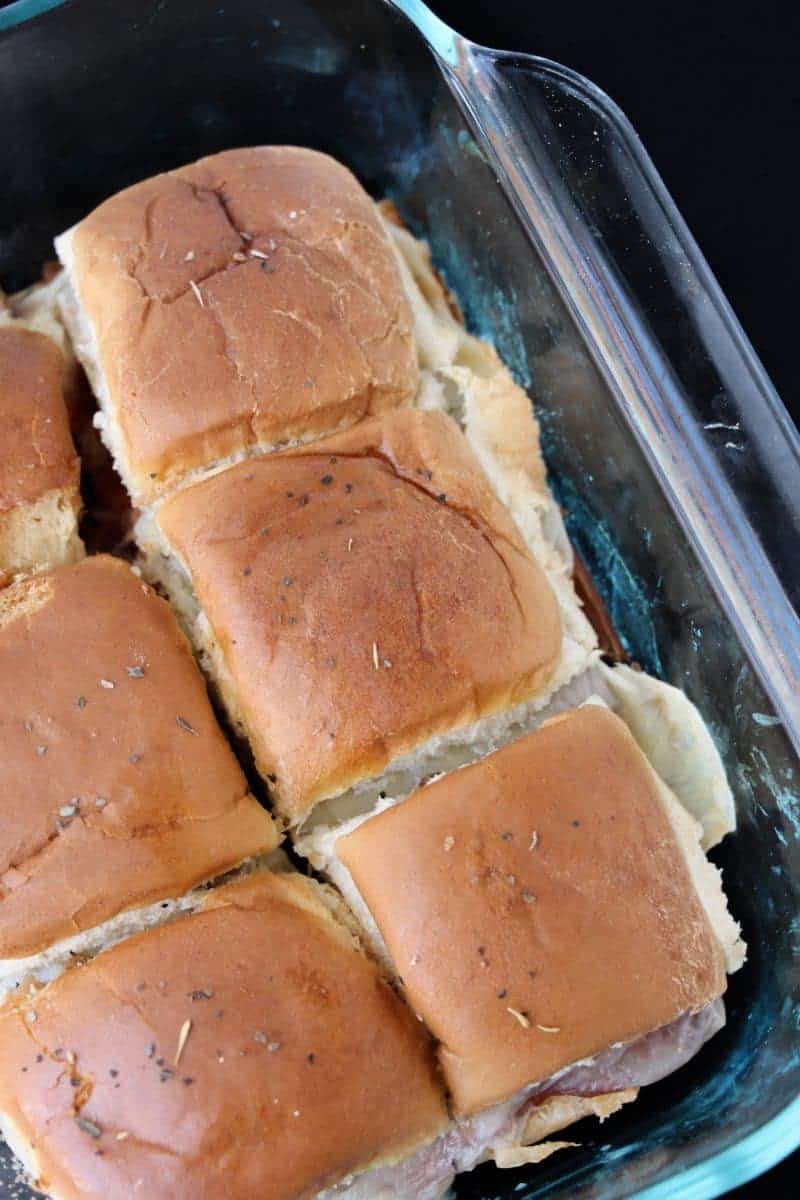 Pull-apart Italian roll sliders on Hawaiian rolls in glass casserole dish.