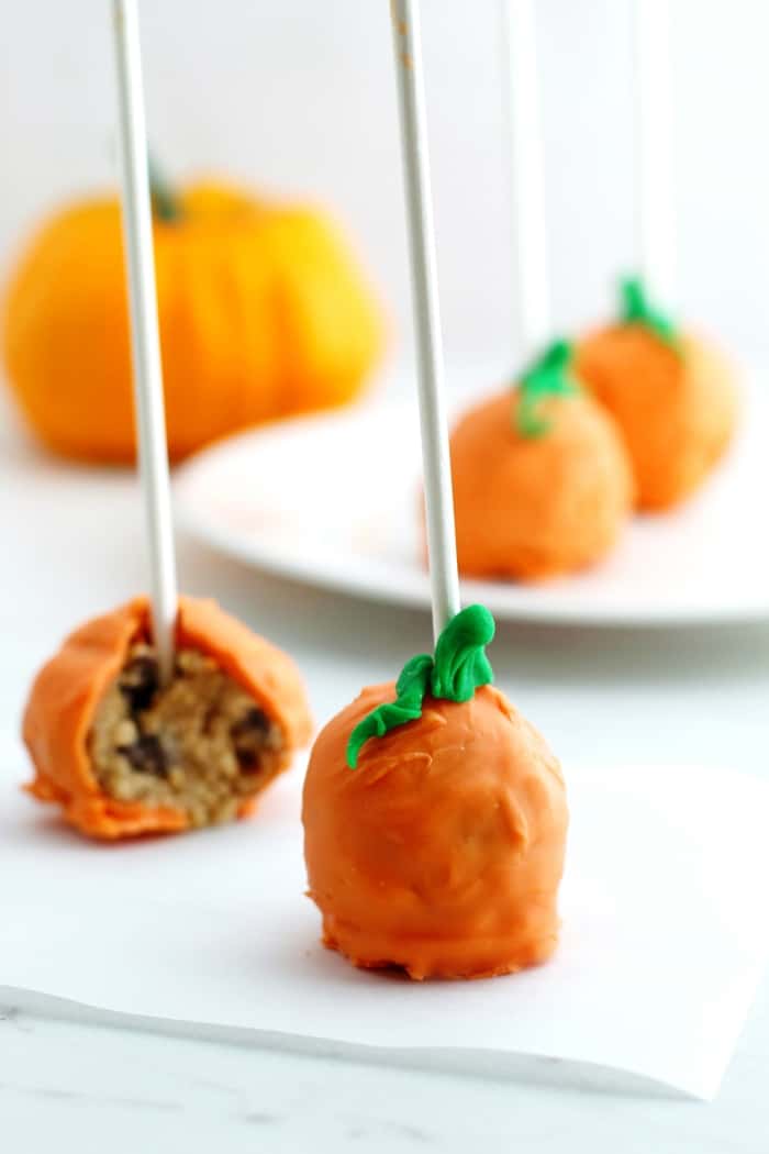 Pumpkin pops are a perfect treat for a Halloween party. These pumpkin-shaped cookie dough pops are easy to make, no oven necessary! 