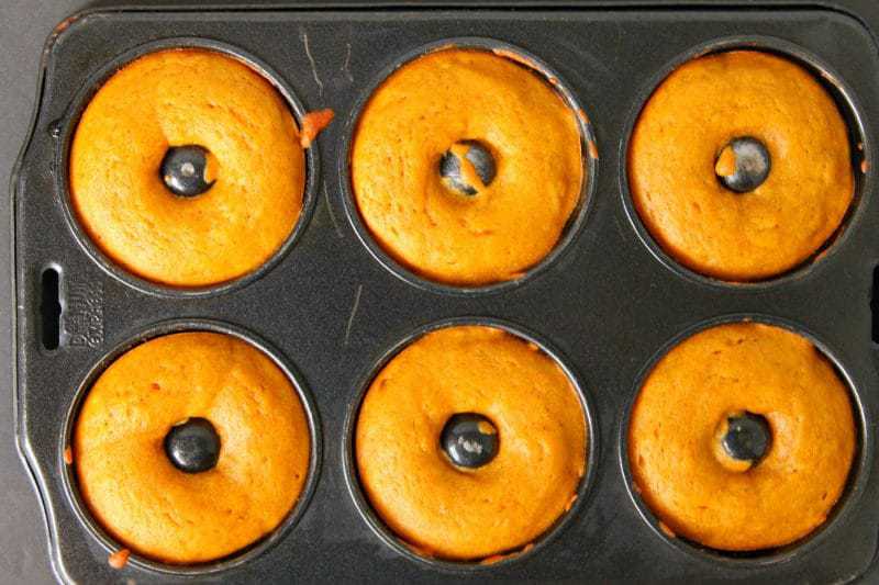 Baked pumpkin doughnuts served warm and smothered with glaze are the perfect Fall recipe for breakfast and dessert alike.