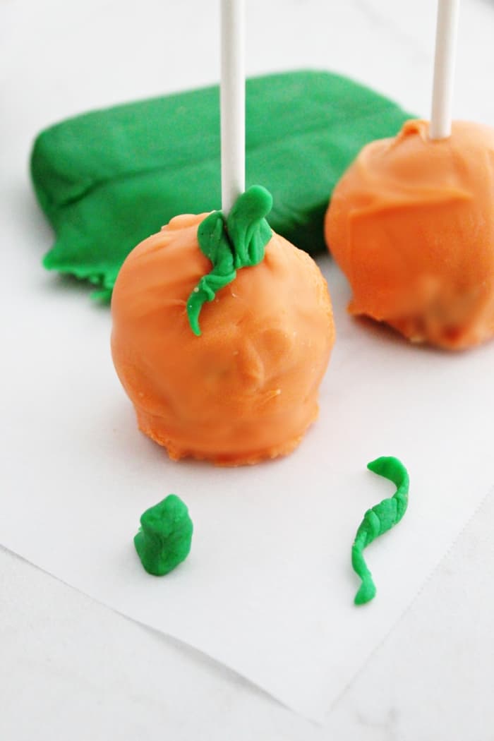 Pumpkin pops are a perfect treat for a Halloween party. These pumpkin-shaped cookie dough pops are easy to make, no oven necessary! 