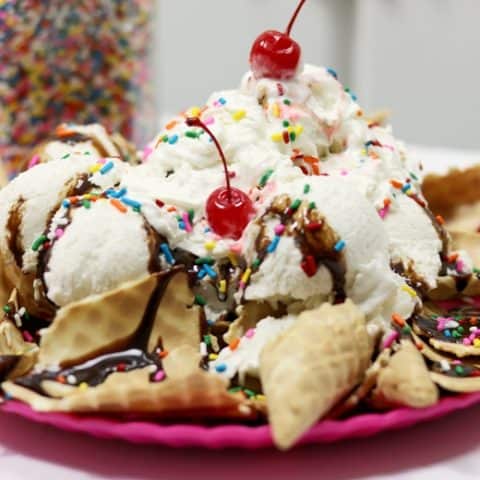 Ice cream sundae on top of a bed of broken ice cream cones.