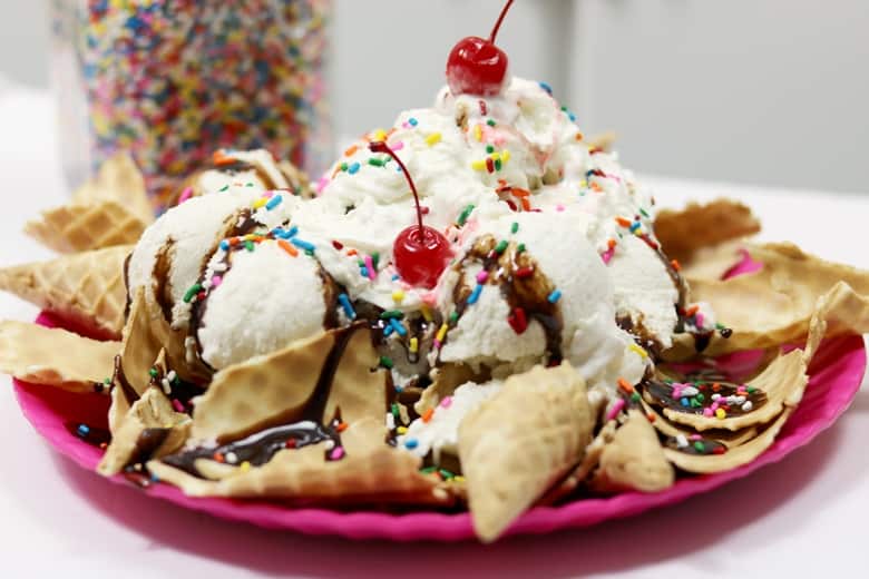 Ice cream sundae on top of a bed of broken ice cream cones.