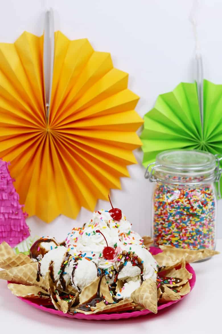 Ice cream nachos sundae and container of rainbow sprinkles