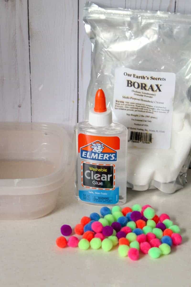 This 4-ingredient pom pom slime features brightly colored pom poms suspended in a clear slime for a bright, colorful, and fun sensory activity for kids.