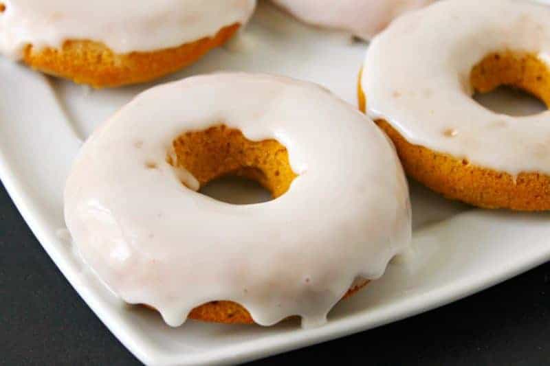 Baked pumpkin doughnuts served warm and smothered with glaze are the perfect Fall recipe for breakfast and dessert alike.