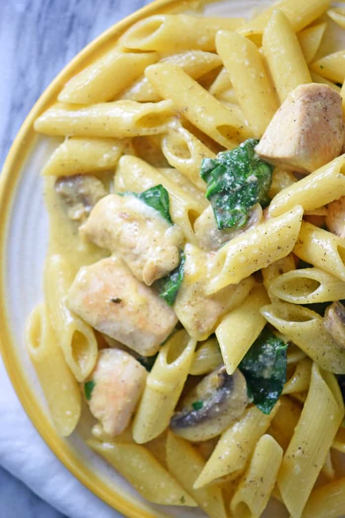 This creamy one-pot chicken pasta recipe takes just 30 minutes to cook. With spinach, mushrooms, and a creamy sauce, everyone in the family will love this easy one-pot meal.