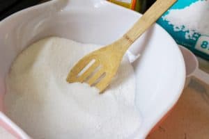 Wooden spoon stirring a bowl of the tablet mixture