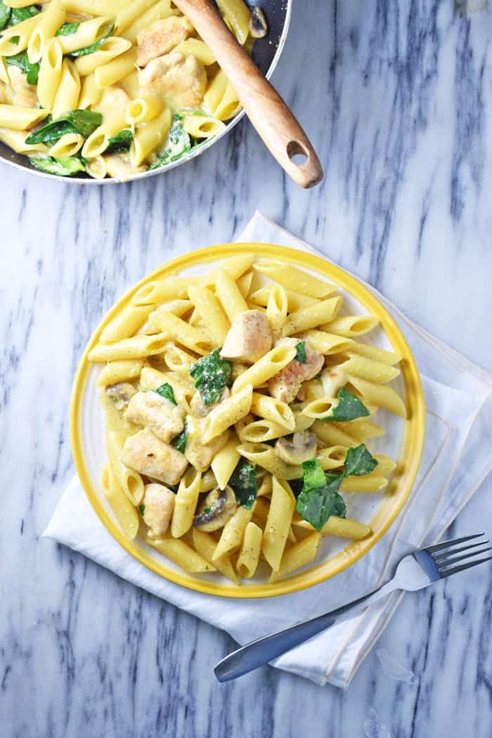 This creamy one-pot chicken pasta recipe takes just 30 minutes to cook. With spinach, mushrooms, and a creamy sauce, everyone in the family will love this easy one-pot meal.