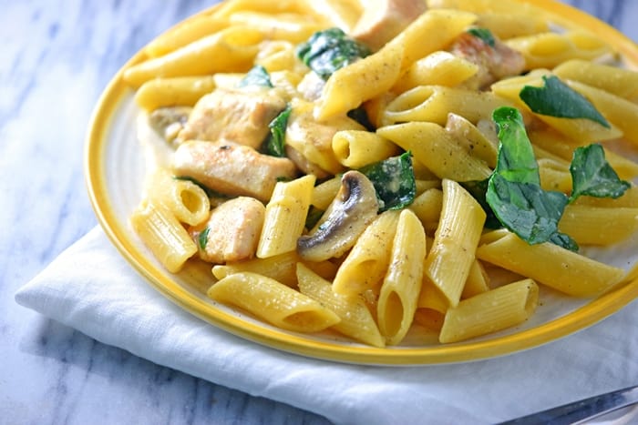 This creamy one-pot chicken pasta recipe takes just 30 minutes to cook. With spinach, mushrooms, and a creamy sauce, everyone in the family will love this easy one-pot meal.