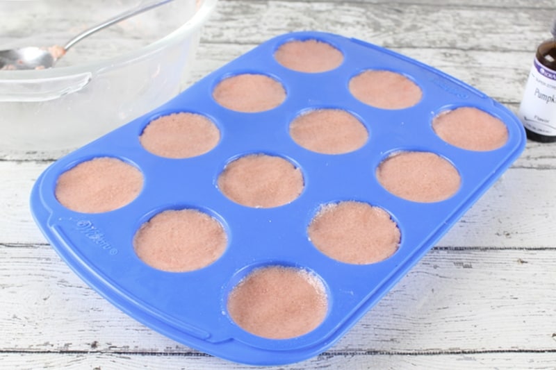 Silicone mini muffin pan filled with pumpkin spice bath bomb mixture
