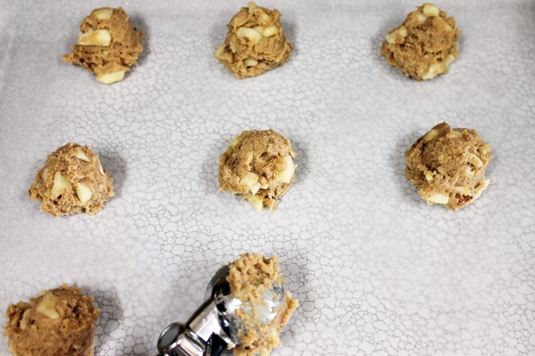 Scooping apple cookie dough onto prepared baking sheet