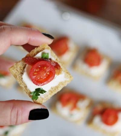 We top Triscuit crackers with cream cheese, bacon, and tomato for a quick and easy holiday appetizer. 