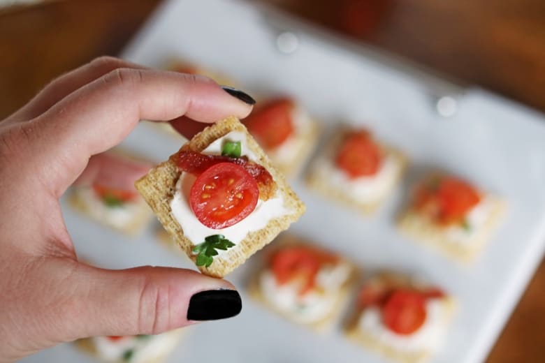 We top Triscuit crackers with cream cheese, bacon, and tomato for a quick and easy holiday appetizer. 