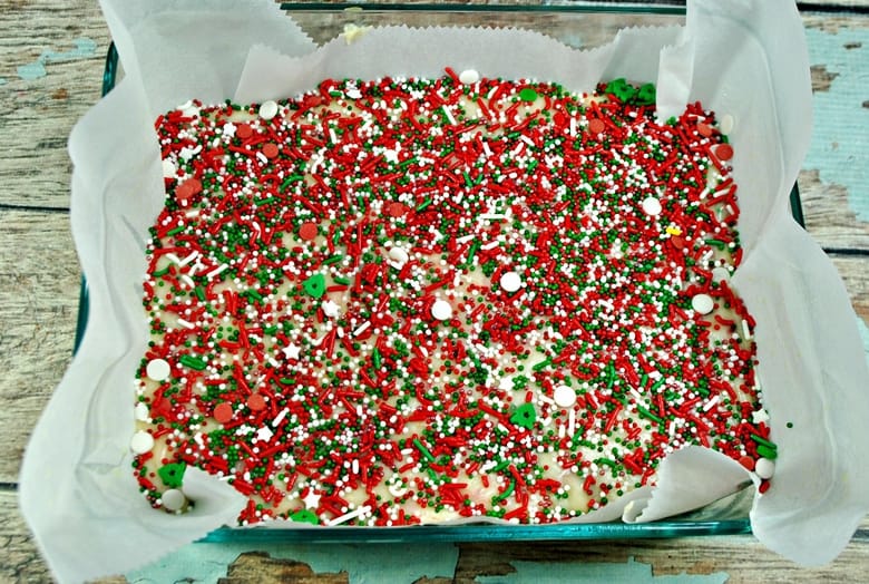 fudge mixture in pan, topped with lots of christmas sprinkles