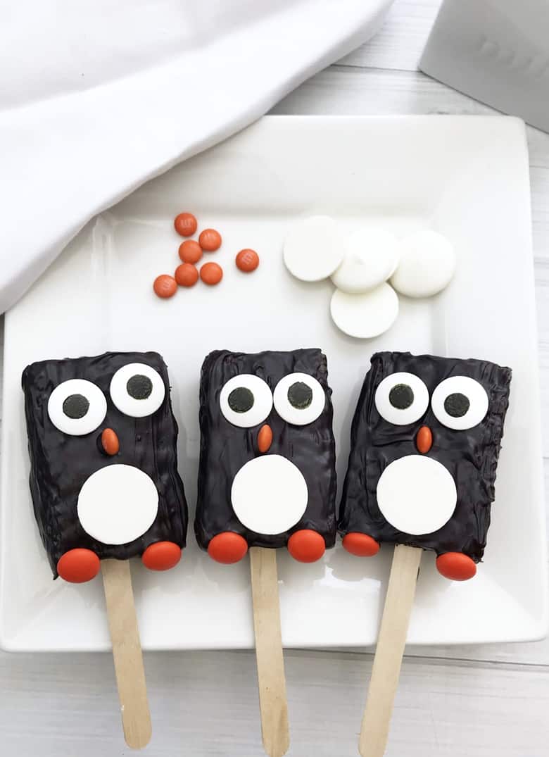 These adorable penguin Rice Krispie Treats take minutes to make using store-bought Rice Krispie Treats, candy melts, and a few candies.