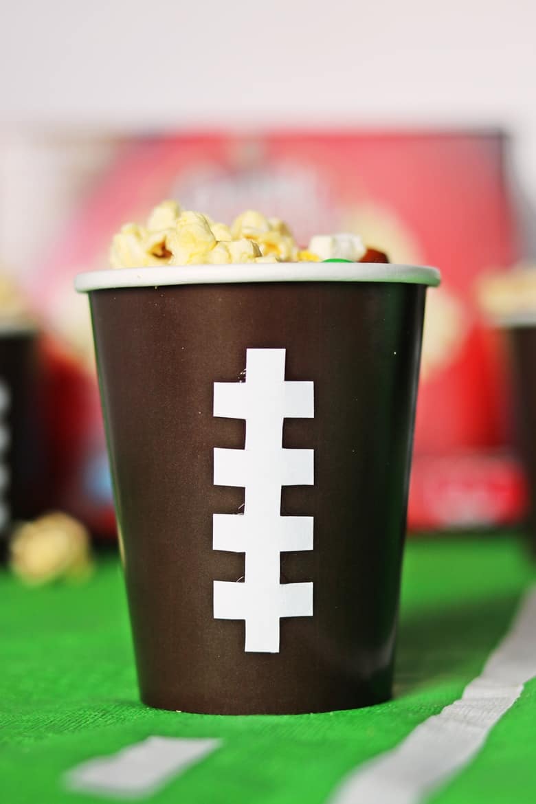 Brown paper cups with white stitching down the front, designed to look like a football