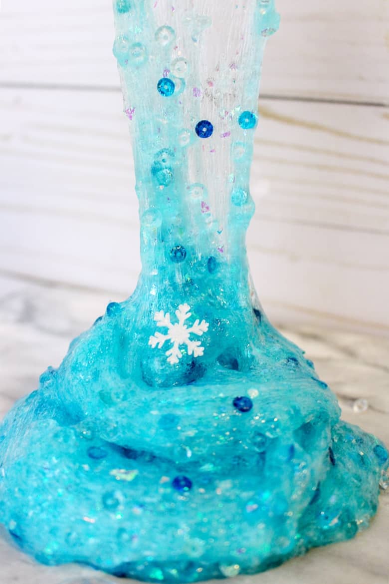 An easy Frozen slime recipe that Elsa would approve of! This glittery snowflake slime makes for a great Winter sensory play activity.