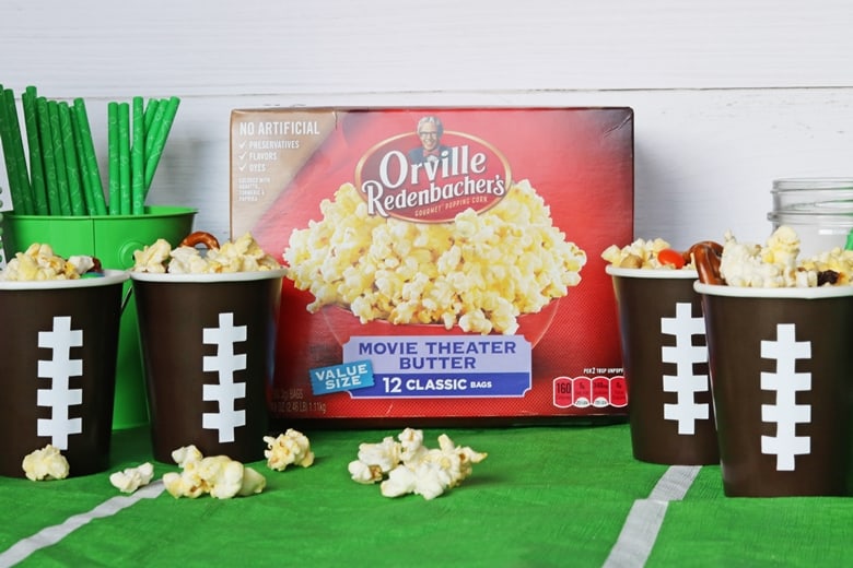 A no-bake sweet & salty snack mix made with popcorn, pretzels, raisins, chocolate, and peanuts. Served in DIY football cups, this easy snack mix is perfect for game day.