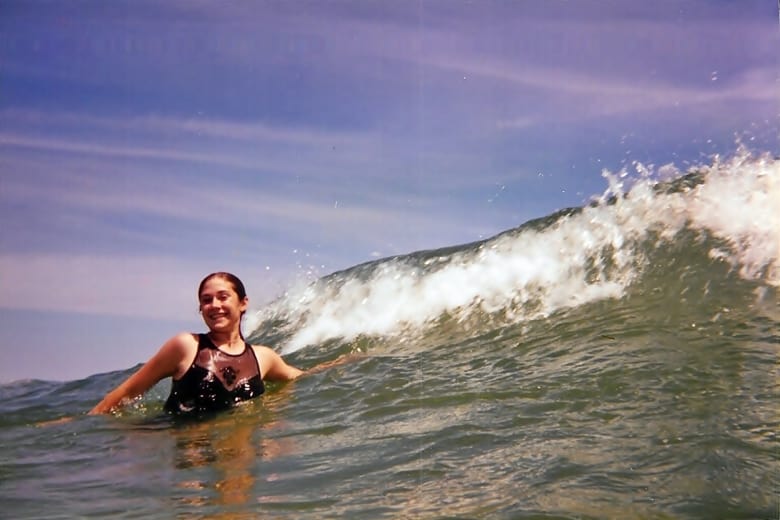 Young Girl Jumping in Waves in the Ocean