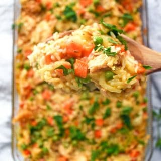 An incredible creamy chicken and rice casserole recipe made with frozen peas and carrots and cream of chicken soup.
