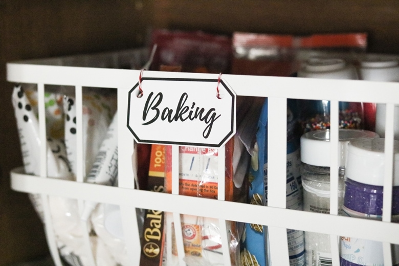 White pantry basket labeled "baking" and filled with baking supplies