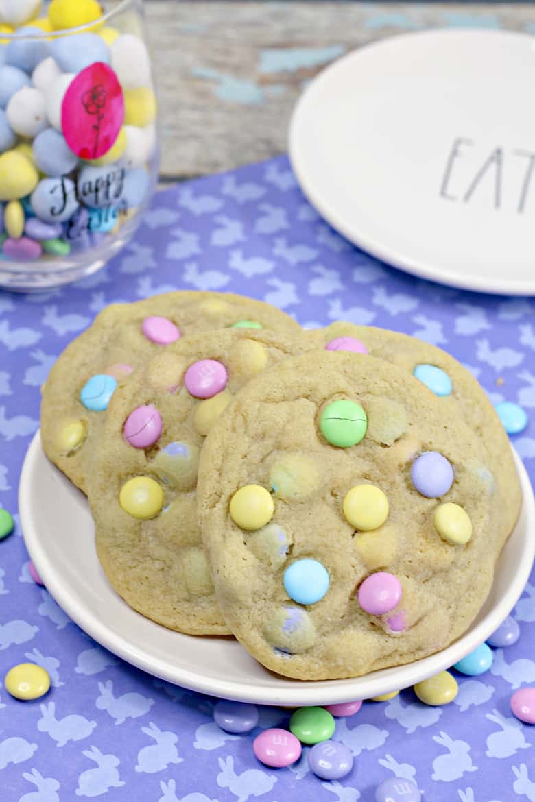 Easter cookies with pastel M&Ms, served on a white plate.