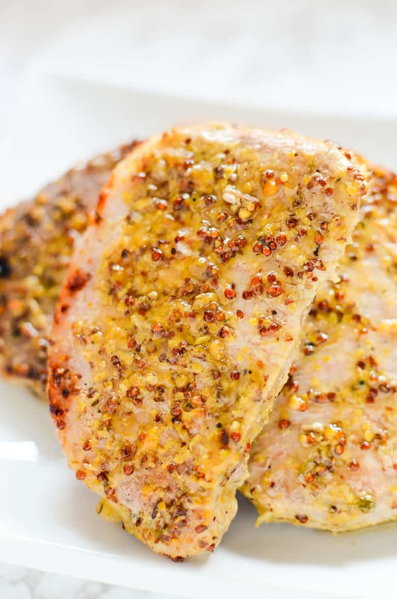Juicy oven roasted pork chops with a delicious honey and grainy mustard sauce. This easy honey mustard pork chop recipe gets dinner on the table in under 40 minutes!