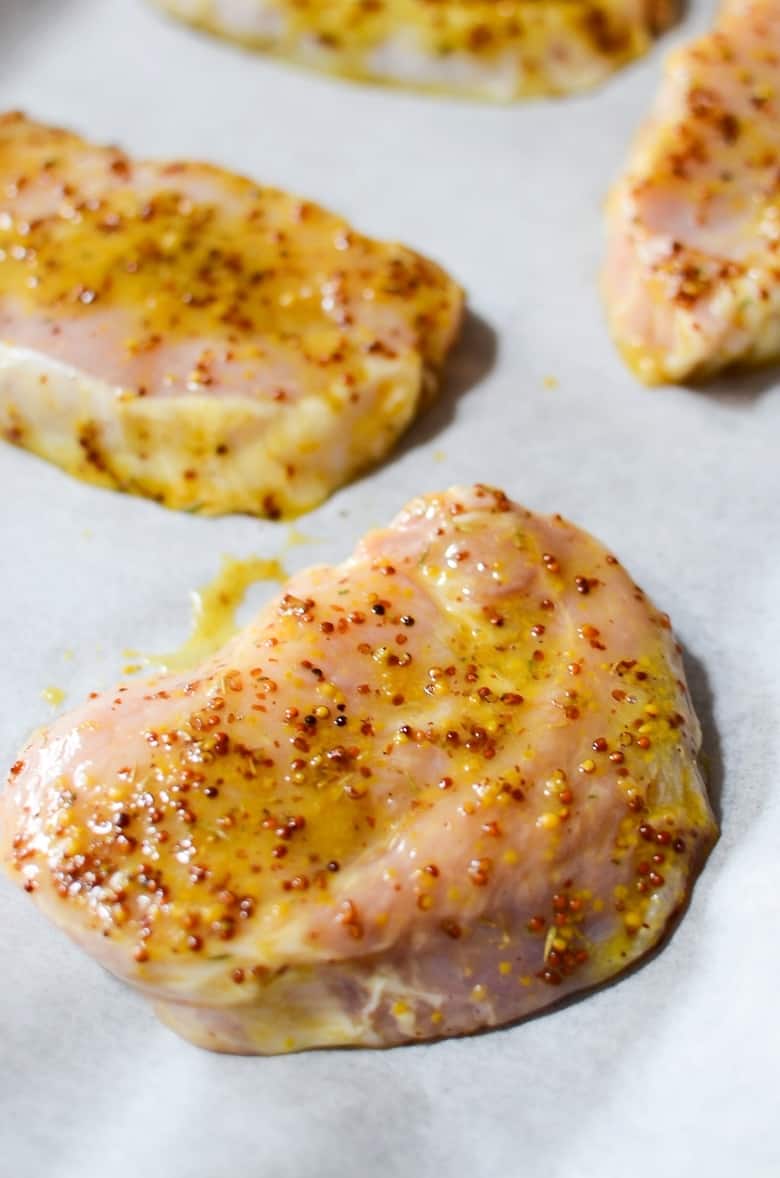 uncooked honey mustard pork chops on lined baking sheet