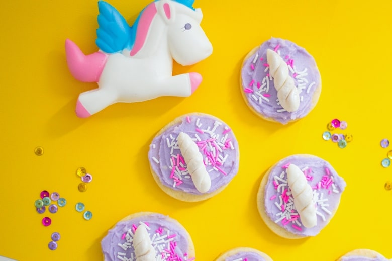 Unicorn cookies, complete with pale purple buttercream frosting and a unicorn horn, make a truly magical dessert for your unicorn party!