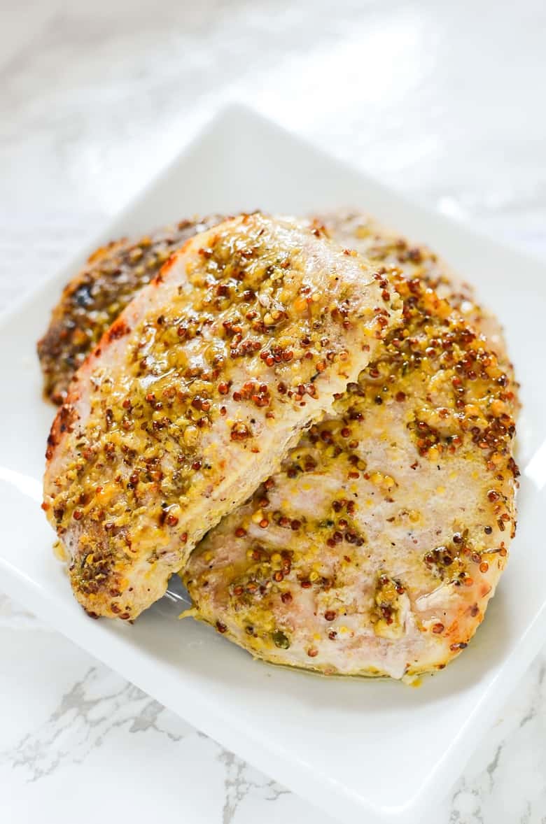 Oven Roasted Pork Chops with Grainy Mustard and Thyme on a white plate