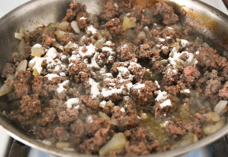 Ground beef in pan sprinkled with flour