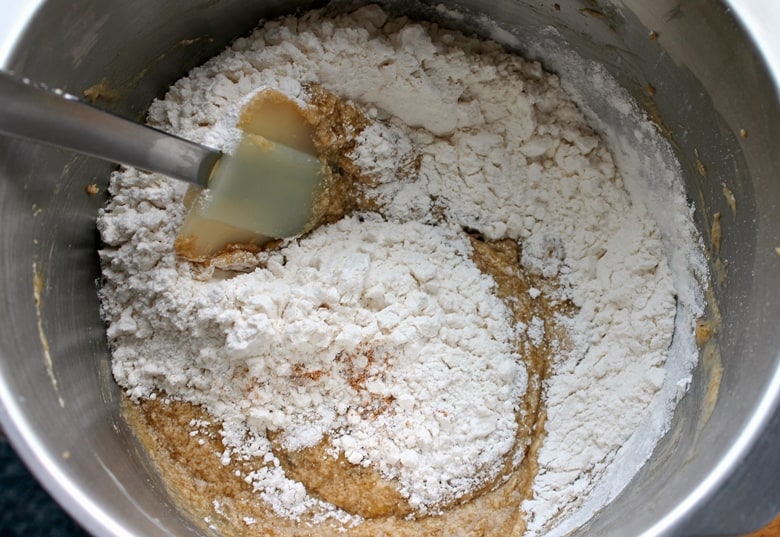 Stirring flour into cookie mixture in bowl