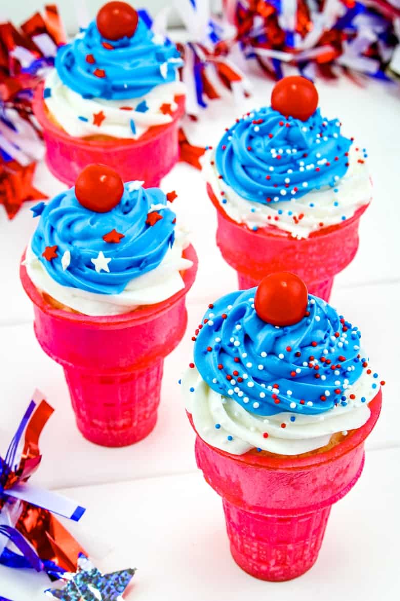 Ice cream cone cupcakes with red cones, white and blue frosting, red, white and blue sprinkles, and a red candy on top.