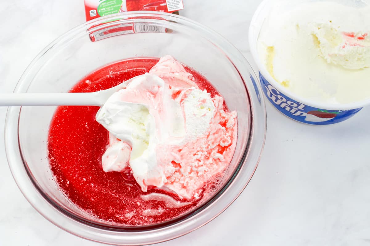Cool Whip being mixed into jello mixture.