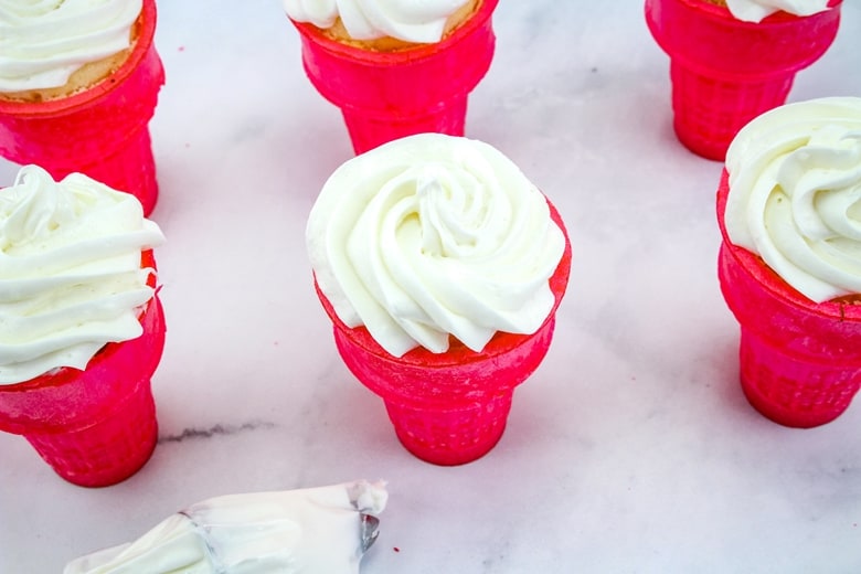 White frosting on top of ice cream cone cupcakes