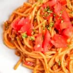 Taco spaghetti topped with tomatoes and cilantro