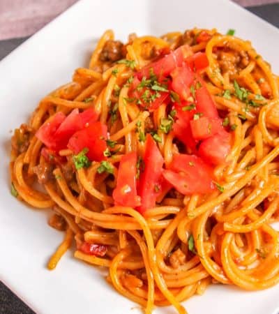 Taco spaghetti topped with tomatoes and cilantro