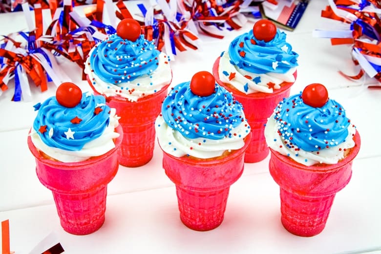4th of July cupcakes in ice cream cones, topped with white and blue icing and patriotic sprinkles.