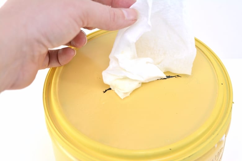 Hand pulling wipe through lid of container