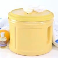 DIY Cleaning Wipes in yellow container with lavender essential oil and a lemon next to them