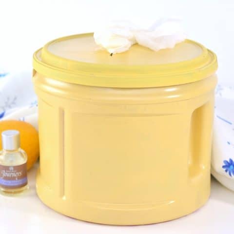 DIY Cleaning Wipes in yellow container with lavender essential oil and a lemon next to them