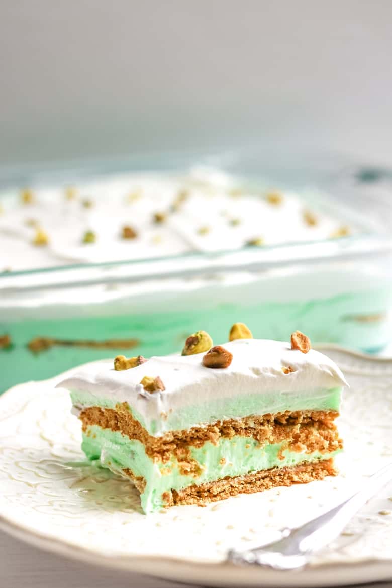 Pistachio Pudding Dessert on plate with 9x13 cake pan behind