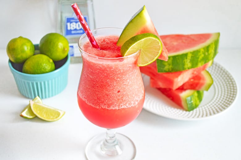 frozen cocktail. watermelon slices, tequila, and bowl of limes