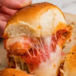 A chicken parm slider with nuggets and melty cheese being pulled from the pan.