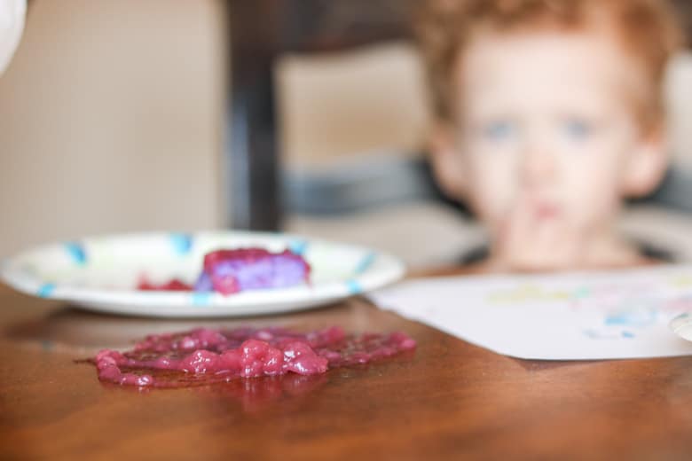 purple paint on table with child in the background