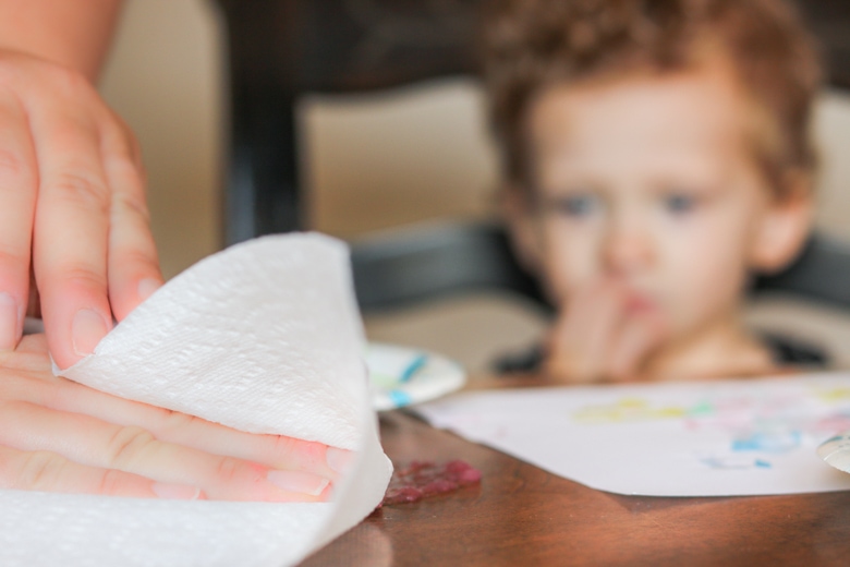 purple paint on table with child in the background