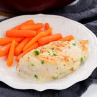 Creamy Garlic Chicken and carrots on white plate with dark blue napkin