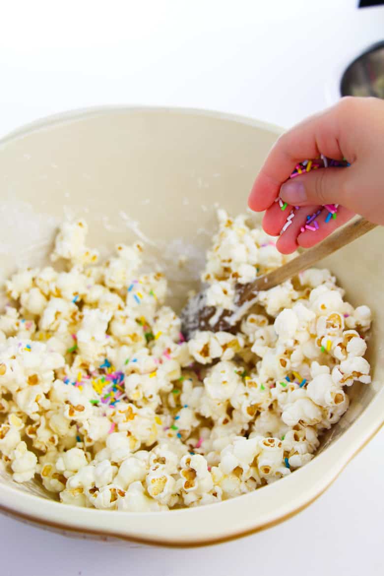 Adding sprinkles to bowl of popcorn